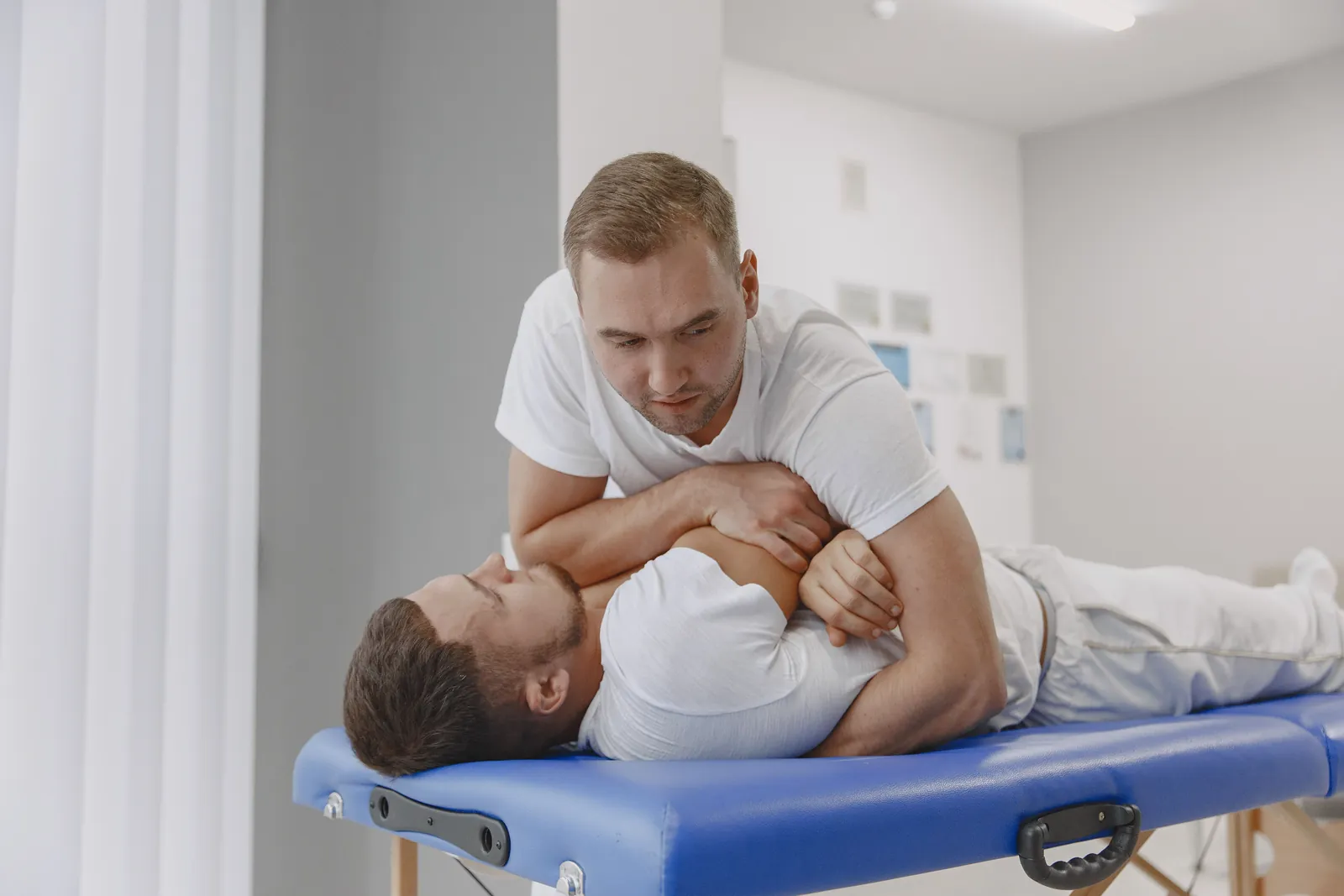 Practitioner giving a hands-on back adjustment to a man on a treatment table, a core part of chiropractic care