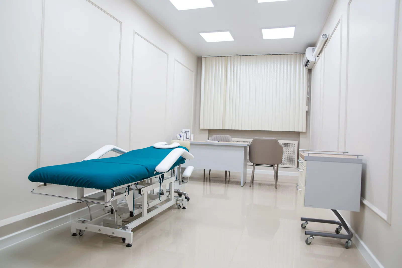 Empty treatment room with a teal table, the kind of room where chiropractic services take place