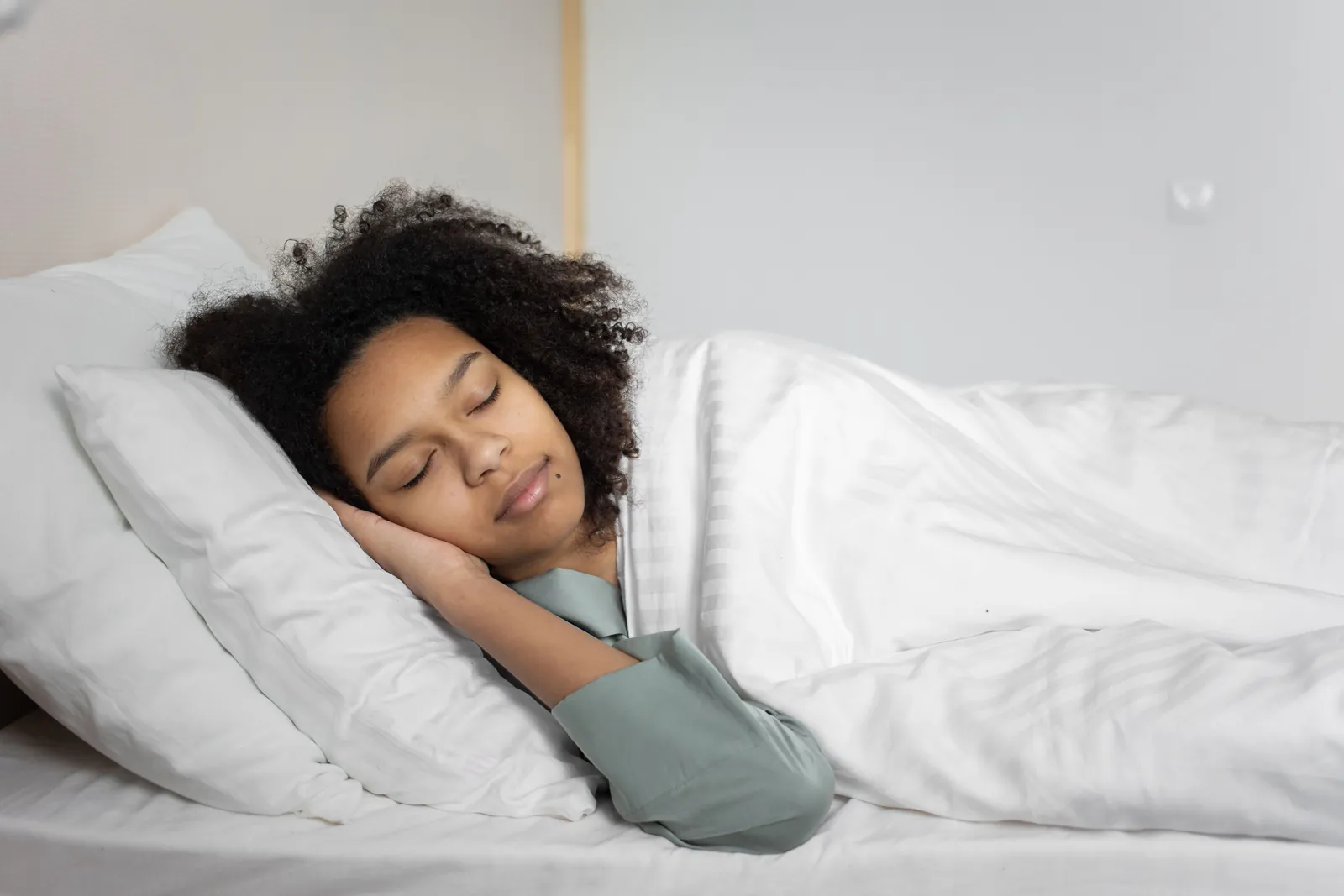 Woman sleeping on her side on a white pillow, a sleep position many people find comfortable