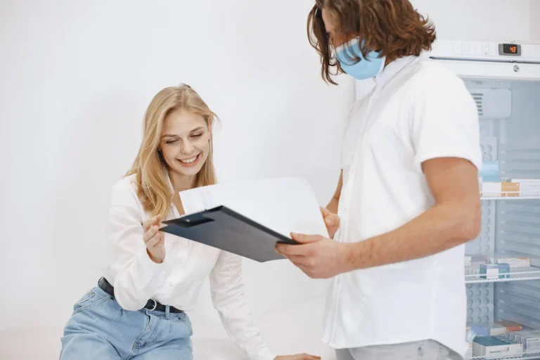 Smiling woman reviewing a chart with a practitioner, as you might with a chiropractor or doctor